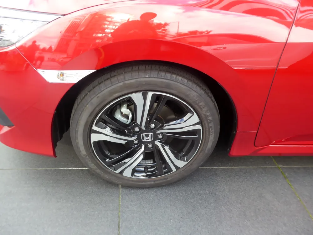 A car wheel with a fitted tire mounted on a vehicle