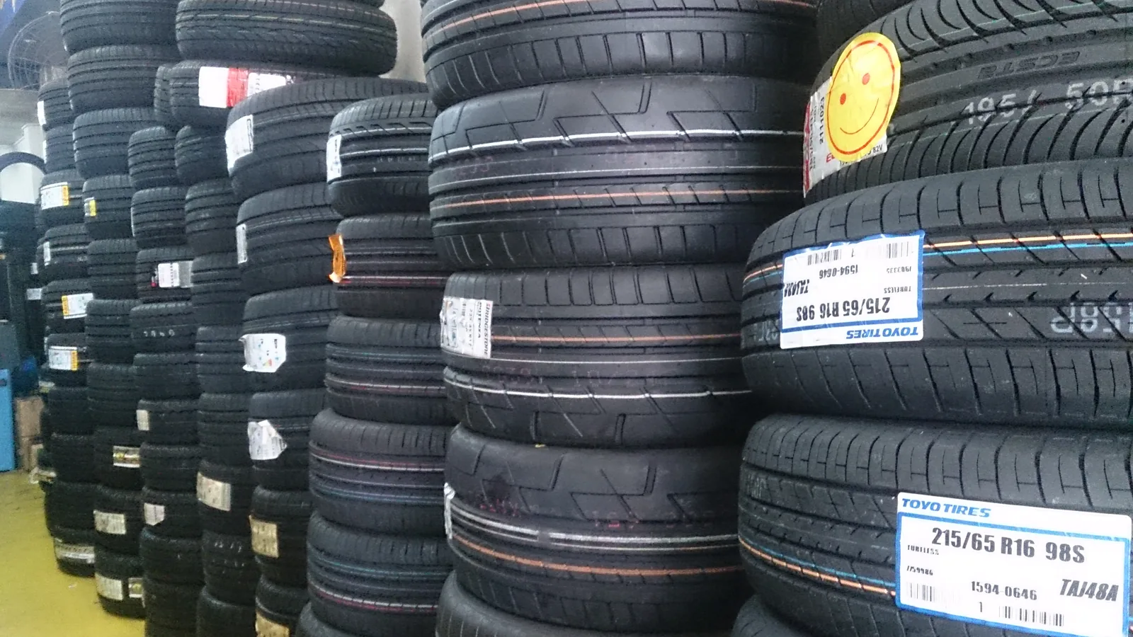 A wall of stacked car tyres with the tread faces toward the camera